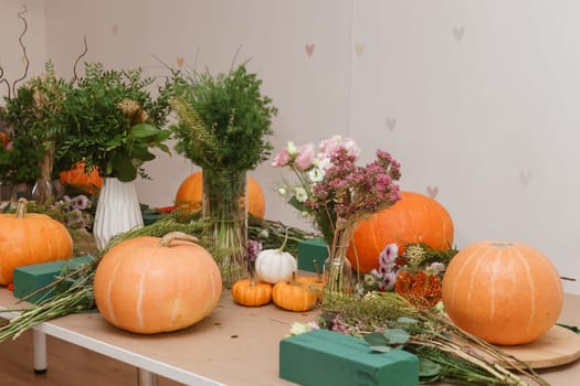 Flower arrangement in a pumpkin, autumn interior decor. Creating handmade autumn decor