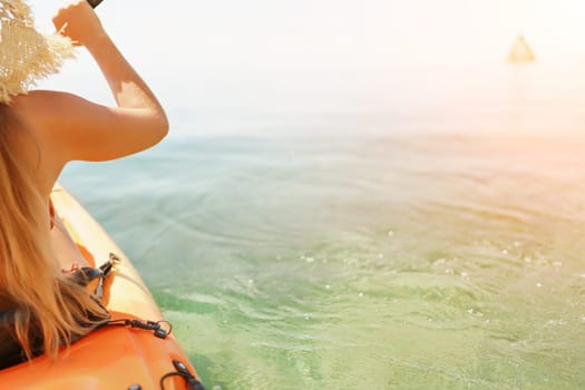 Woman in kayak back view. Happy woman with long hair in a swimsuit and hat floating in kayak on the sea. Summer holiday vacation. Summer holidays vacation at sea