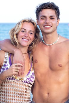 Smiling multiethnic woman and man enjoying vacation. Beautiful and cheerful couple of generation z pose for a photo with a mobile phone.