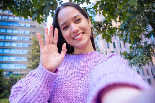 Happy young latin taking a selfie with smartphone.