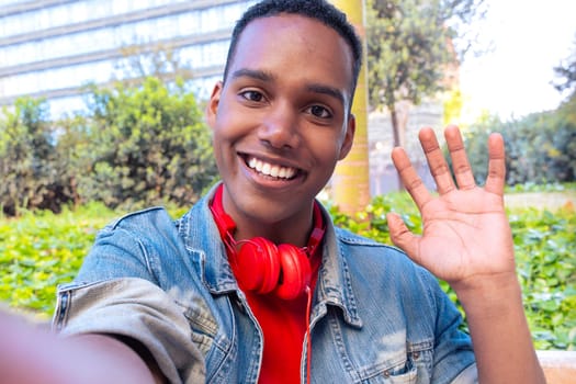 Happy young african american taking a selfie with smartphone outdoors