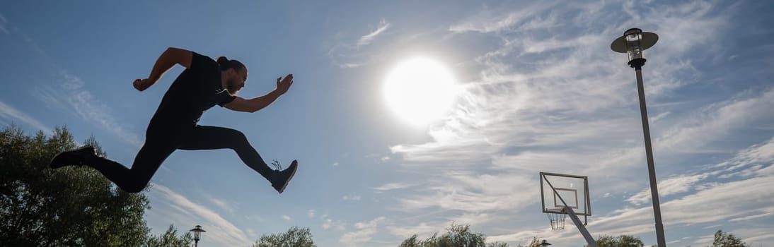 Caucasian man jumping with high hip raise outdoors
