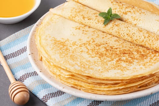 Stack of traditional russian pancakes blini on gray background with copy space. Homemade russian thin pancakes blini. Russian food, russian kitchen.