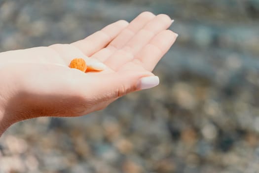 Woman eating milky almond nuts. A young caucasian woman choping fresh green almond after morning fitness yoga near sea. Only hands are visibly. Healthy vegan food. Slow motion. Close up