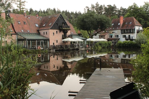 View of a residential building with a cafe-restaurant by the river in the forest. High quality photo