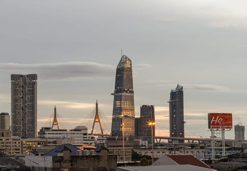 Bangkok, Thailand - Aug 14, 2024 - City view with KingBridge tower alongside the iconic landmark of Bhumibol Bridge. Stunning At Twilight skyline of bangkok business district with Skyscrapers use it as your wallpaper, poster and banner design, Selective focus.