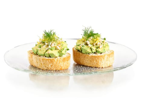 Canapes crab salad with avocado on a toasted crostini served on a transparent glass tray. Food isolated on transparent background.
