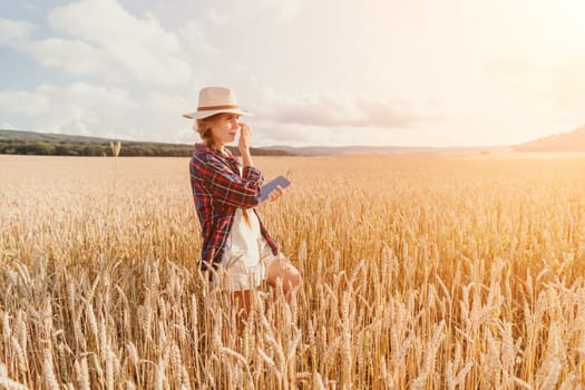 Woman farmer walks through a wheat field at sunset, touching green ears of wheat with his hands. Hand farmer is touching ears of wheat on field in sun, inspecting her harvest. Agricultural business.