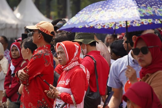17 August 2024, Jakarta, Indonesia. The atmosphere near the Jakarta Palace during Indonesia's Independence Day is electric, filled with patriotic fervor and national pride. Crowds of people, dressed in red and white, gather to witness the flag-raising ceremony and participate in various festivities.