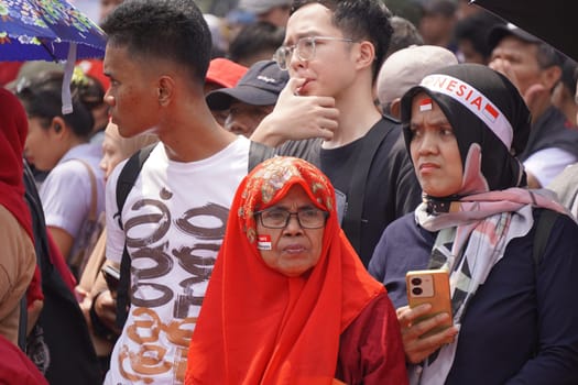 17 August 2024, Jakarta, Indonesia. The atmosphere near the Jakarta Palace during Indonesia's Independence Day is electric, filled with patriotic fervor and national pride. Crowds of people, dressed in red and white, gather to witness the flag-raising ceremony and participate in various festivities.