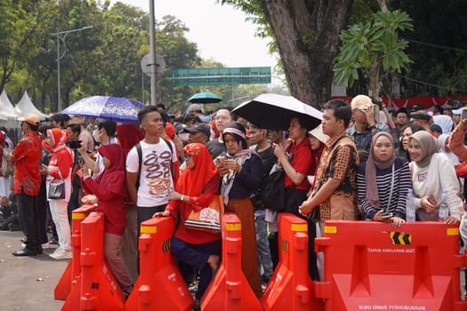 17 August 2024, Jakarta, Indonesia. The atmosphere near the Jakarta Palace during Indonesia's Independence Day is electric, filled with patriotic fervor and national pride. Crowds of people, dressed in red and white, gather to witness the flag-raising ceremony and participate in various festivities.