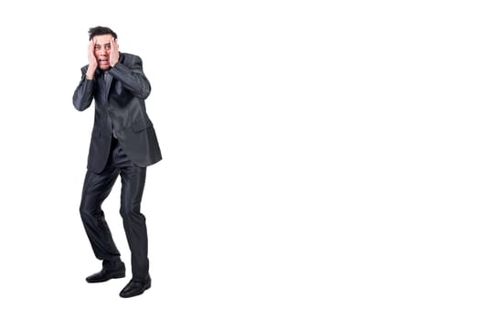 Full body of scared man in elegant suit looking away with hands on face isolated on white background in studio