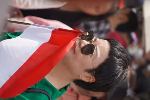 17 August 2024, Jakarta, Indonesia. The atmosphere near the Jakarta Palace during Indonesia's Independence Day is electric, filled with patriotic fervor and national pride. Crowds of people, dressed in red and white, gather to witness the flag-raising ceremony and participate in various festivities.