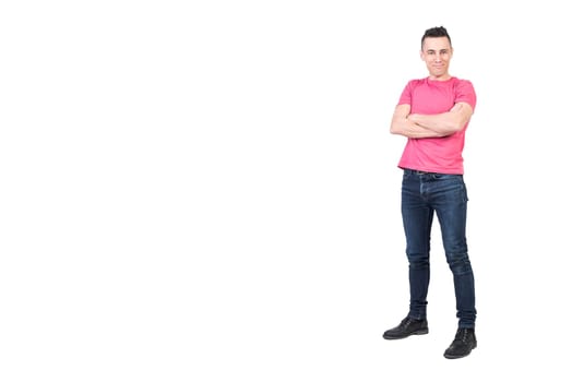 Full body of positive young male model in casual outfit looking at camera with crossed arms isolated on white background
