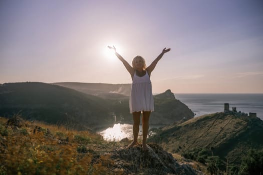 woman standing hill with her arms raised in the air, looking up at the sun. The scene is peaceful and serene, with the woman's expression conveying a sense of joy and happiness