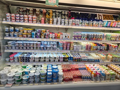 17 August 2024, Jakarta, Indonesia. a refrigerated section in a grocery store stocked with various drinks, snacks, and yogurt products. There are juices, yogurts, jelly, and other snacks on display.