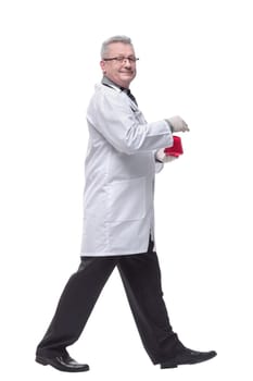 Side view of walking lab scientist isolated on white background holding beaker of red liquid