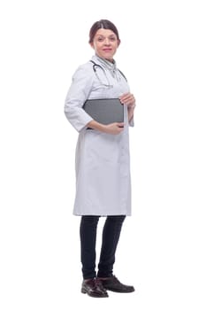 Smiling female doctor with lab coat in her office holding a clipboard with medical records, she is looking at camera