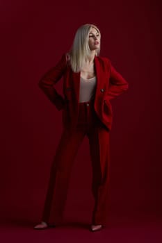 Portrait of a blonde woman in red dress on a red background