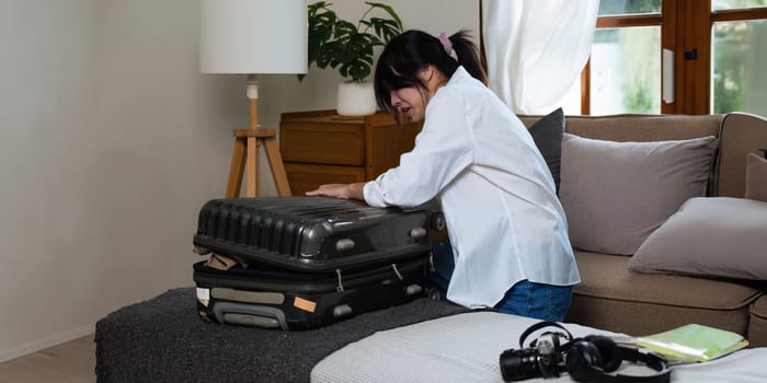 Young asian woman traveler serious about pack bags prepare for the travel season vacation, concept lifestyle active journey and trip travel, passport.
