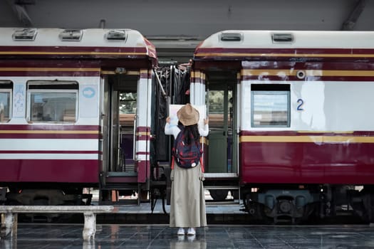 Young woman with suitcase for tourist adventure holiday traveling standing and looking at the map with a train. concept transport lifestyle active journey and travel lifestyle travel.