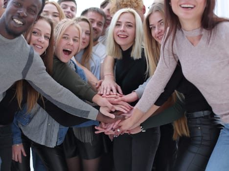 close up. a group of young people making a tower out of their hands.