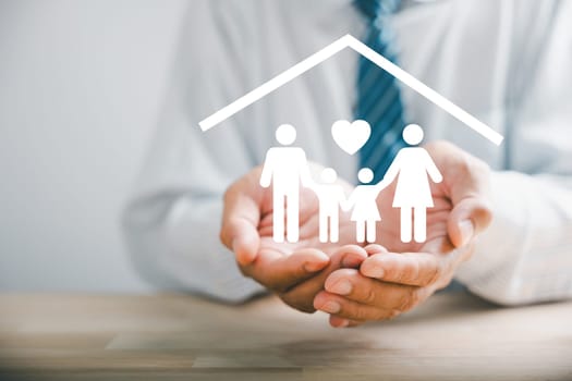 Fostering family well-being, Businessman protective gesture resonates with young family silhouette. Health and house insurance icons underscore safety and care, emphasizing family support.