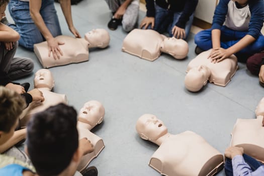 First aid cardiopulmonary resuscitation course in primary school. Kids practicing on resuscitation dolls.