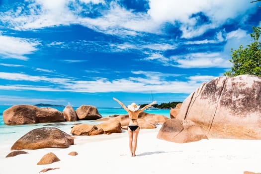 Happy woman rising hands to the sky on summer vacations on Seychelles.