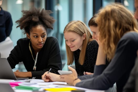 Group of diverse young professionals collaborating on a project in a modern office setting.