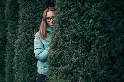 Autumn portrait of beautiful woman on thuja nature background