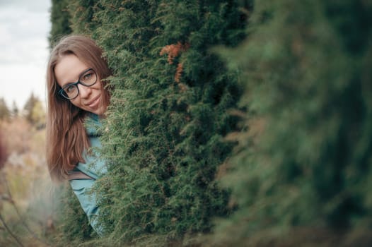Autumn portrait of beautiful woman on thuja nature background