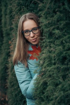 Autumn portrait of beautiful woman on thuja nature background