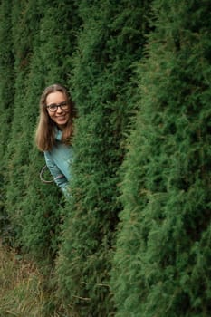 Autumn portrait of beautiful woman on thuja nature background