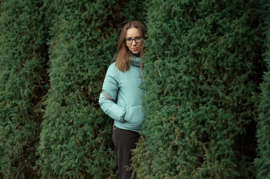 Autumn portrait of beautiful woman on thuja nature background