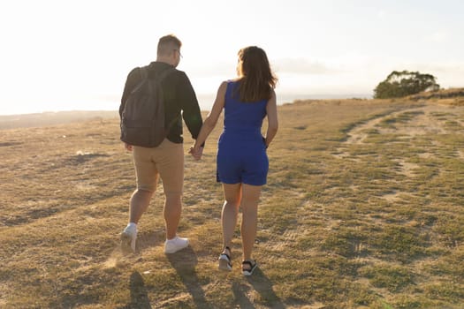 Young couple is enjoying a romantic walk in nature on a beautiful summer evening