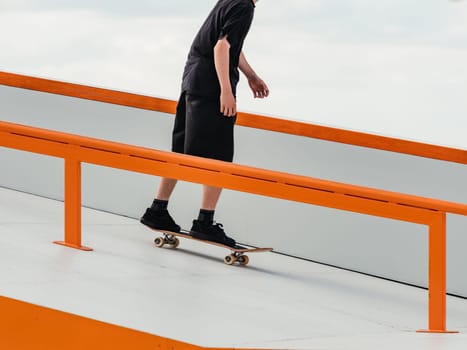 Skateboard Skater Skating in Skate Park Outdoor. Professional skater athlete in black jeans rides a skateboard. Modern sport, subculture and skateboarding concept. Skate as hobby and healthy lifestyle