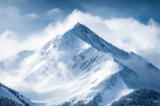 Towering snow-covered mountain peak with dramatic clouds and forested slopes in winter landscape.