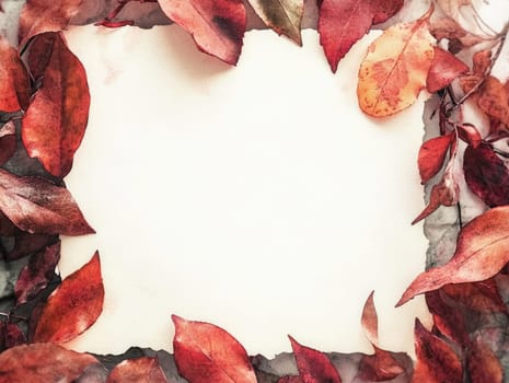 Colorful autumn leaves surround a blank parchment sheet, resting on a textured marble background.