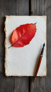 A bright red leaf sits atop blank paper next to an antique fountain pen, all placed on a weathered wooden table.