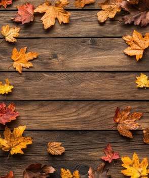 Colorful autumn leaves lie on a rustic wooden table, creating a warm, seasonal ambience with shades of yellow, orange, and red.
