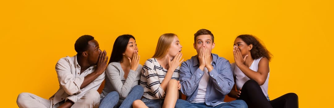 International group of students gossiping over yellow studio background, student lifestyle