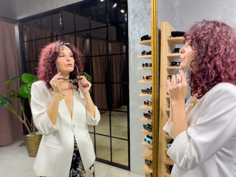 Shopping woman, women's fashion clothes in a store, boutique. Woman choosing clothes in a store.