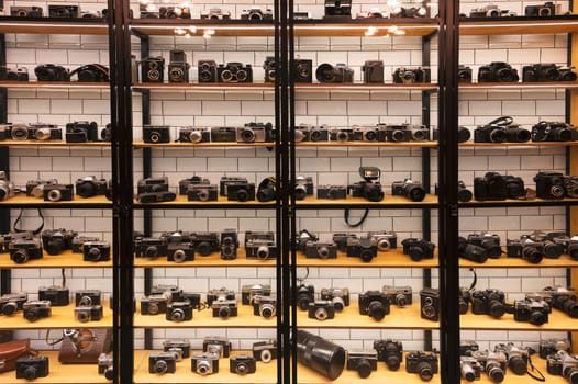 Many retro different film photo cameras on rack