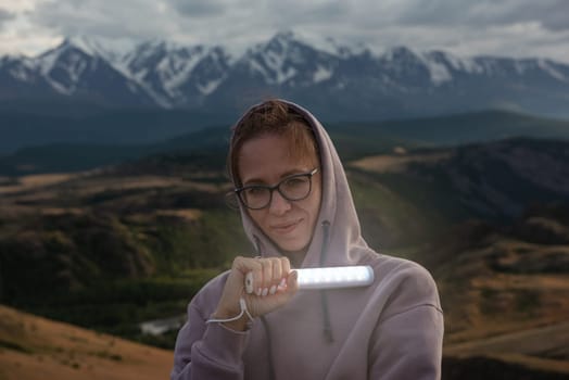 Woman with flashlight in summer Altai mountains in Kurai steppe