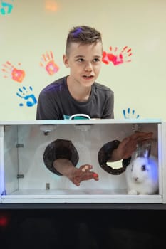 Blind guess game by touch . Young boy guesses by touch that he does not see in the box, rabbit in the box. Happy birthday celebrating or games with friends concept