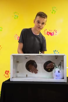 Blind guess game by touch . Young boy guesses by touch that he does not see in the box, rabbit in the box. Happy birthday celebrating or games with friends concept