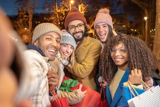 Cheerful group of friends taking selfie with Christmas shopping presents. having fun together. High quality photo