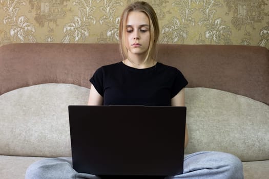 Woman comfortably sits on cozy sofa while using her laptop, embodying the essence of modern remote work