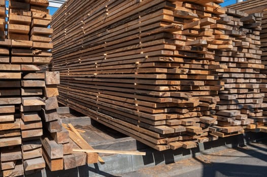 Stacked wooden planks close-up at lumber warehouse. Wood industry concept
